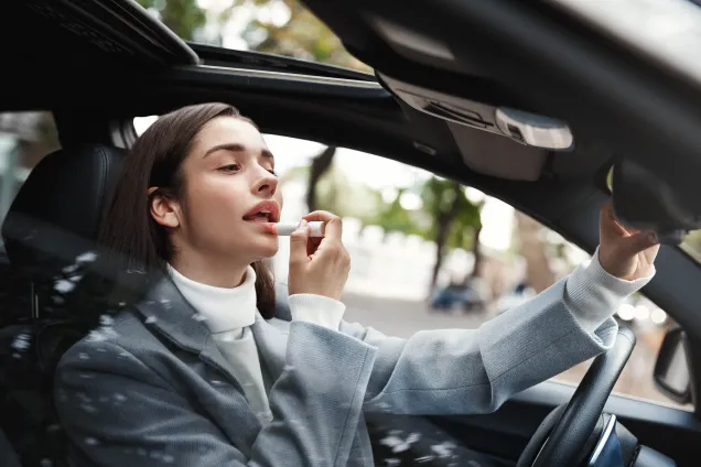 woman driver applying lipstick 